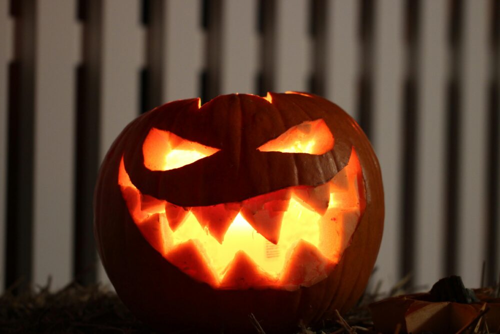 Creepy carved pumpkin glowing in the dark, perfect for Halloween decor.